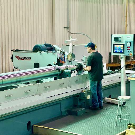 Precision cylindrical grinding of a large compressor shaft at HFW Industries.